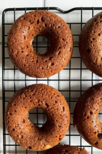 Baked donuts on a wire rack.