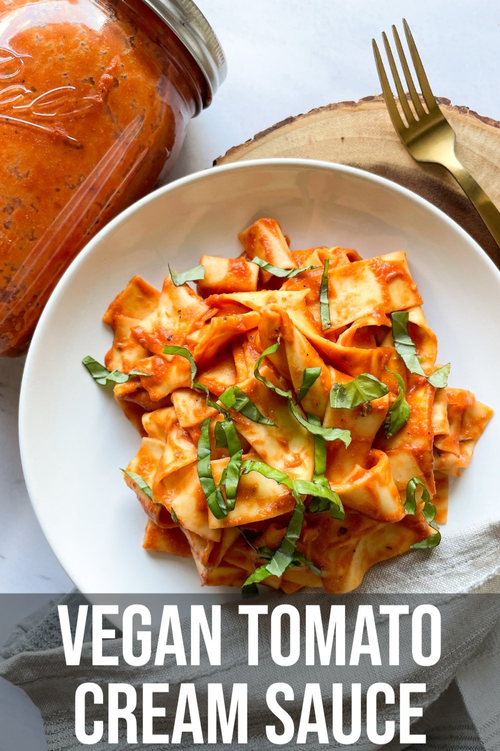 pasta with vegan tomato cream sauce on a white plate with text overlay