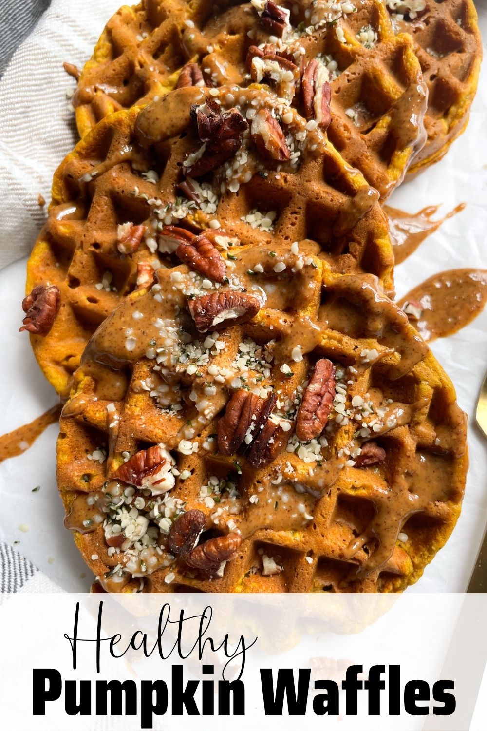 pumpkin waffles on plate with almond butter, hemp seeds and pecans